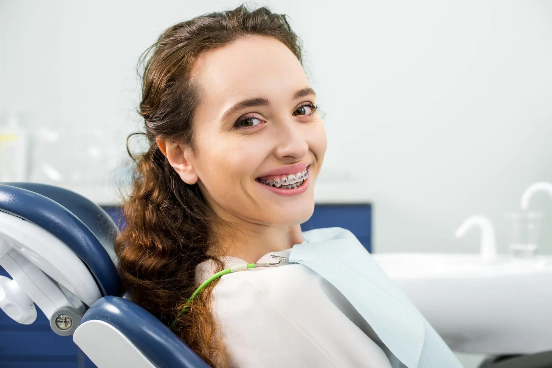 Smiling adult with braces in the dental chair