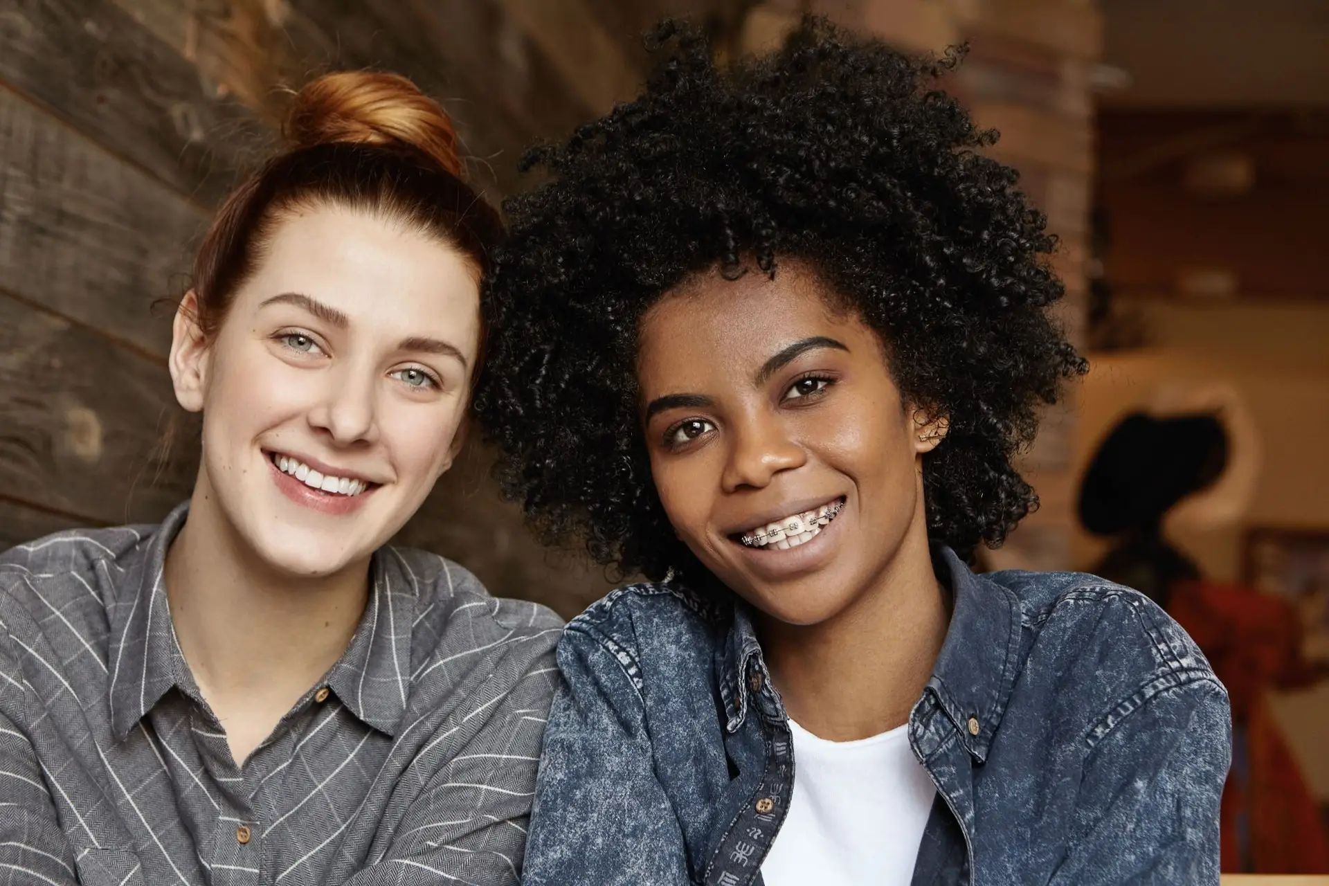 Two smiling friends, one wearing braces