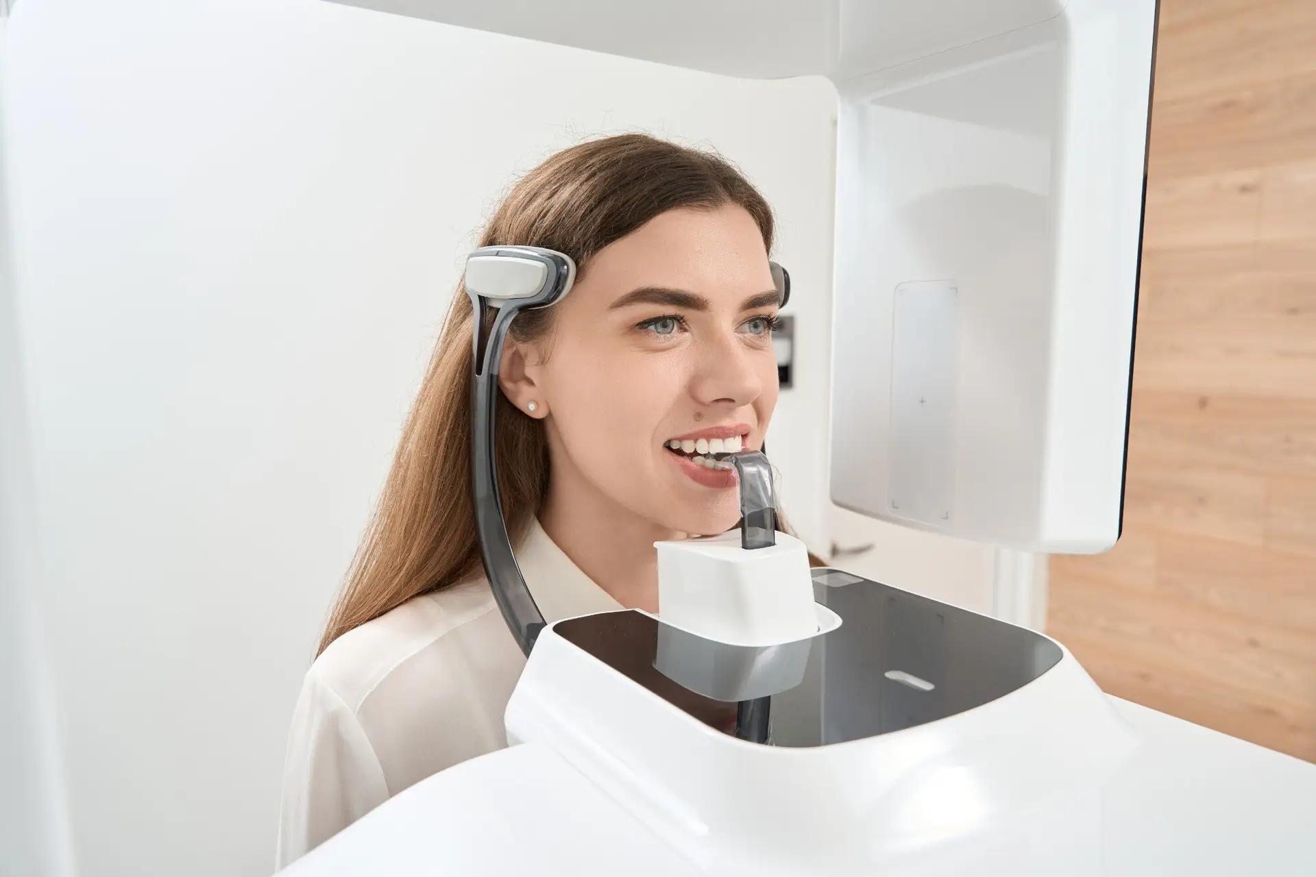 Woman smiling during digital panoramic and 3D X-ray imaging