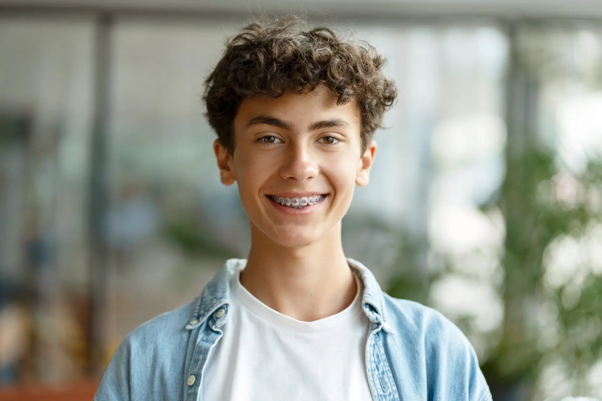 Smiling teen boy with curly hair and braces
