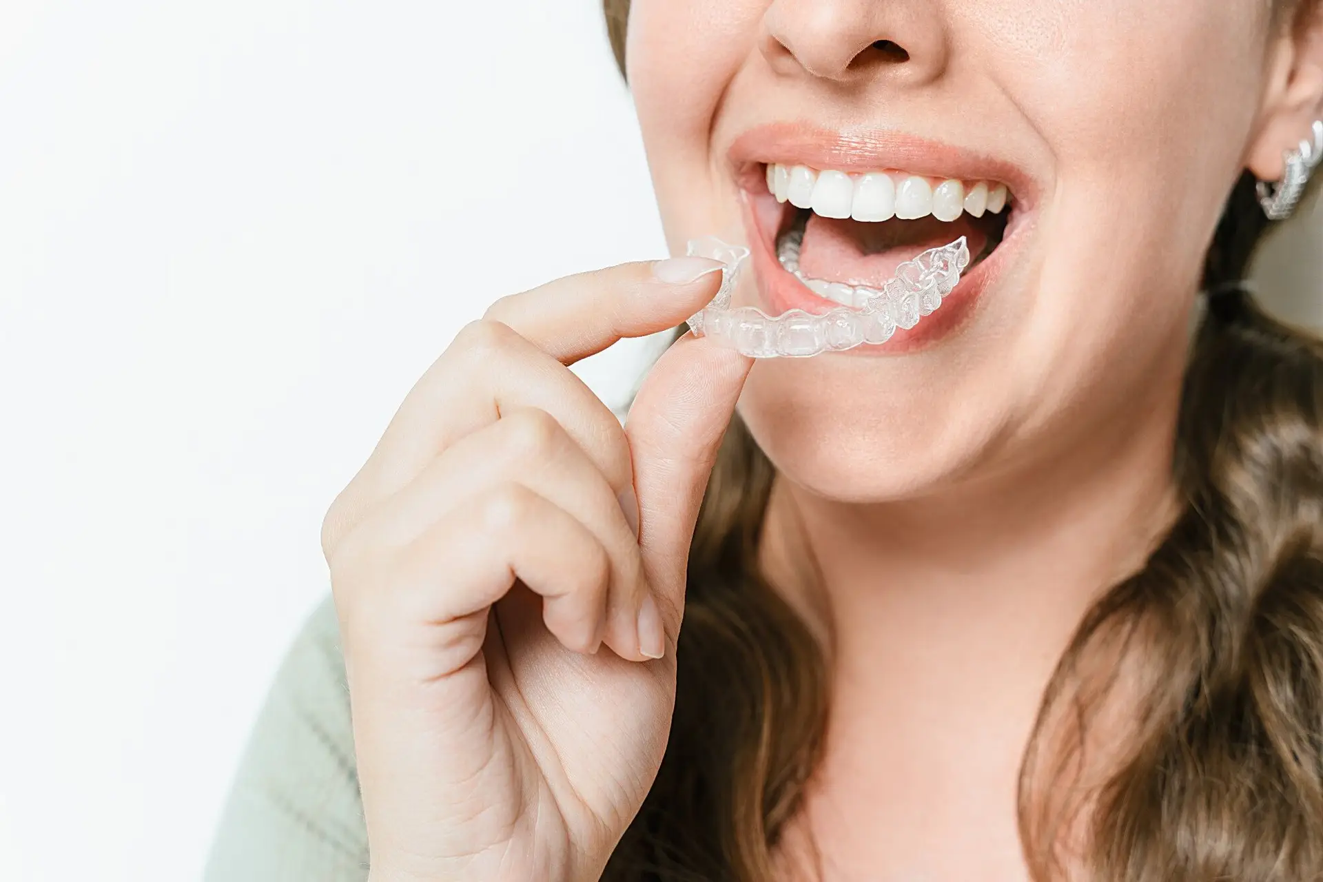 Smiling woman putting in her clear aligner